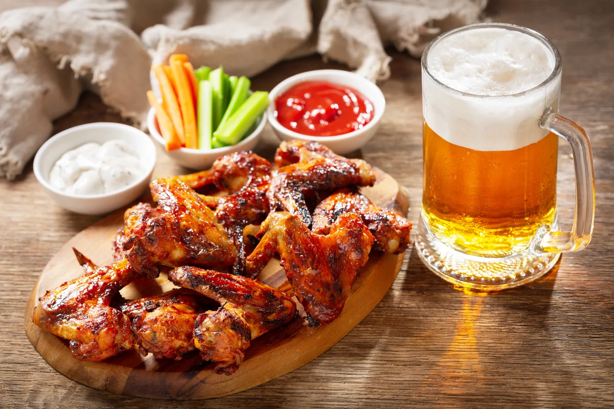 bufffalo wings and beer on a table