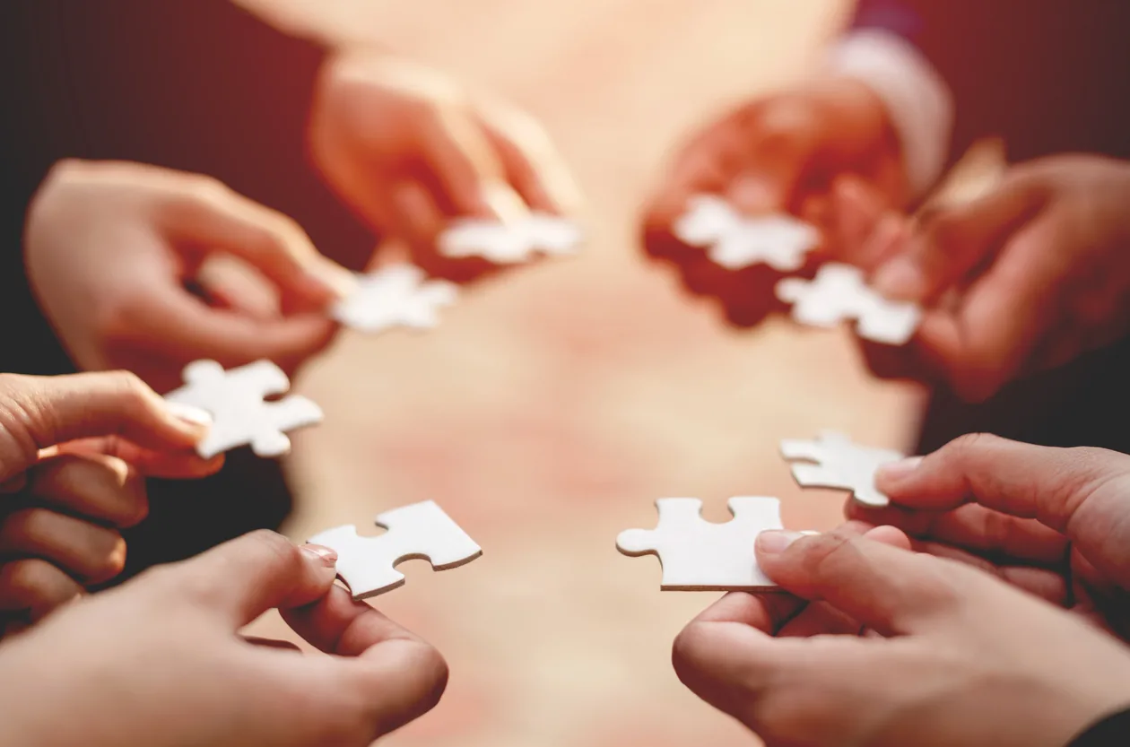 people bringing puzzle pieces together